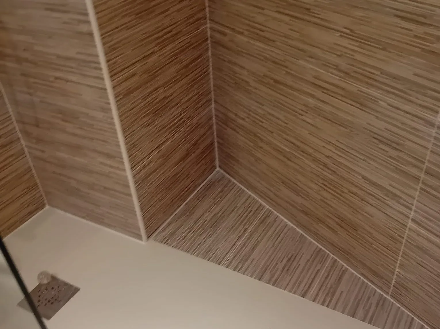 Plato de ducha blanco a ras de suelo con alicatado imitación madera, de MS Reformas