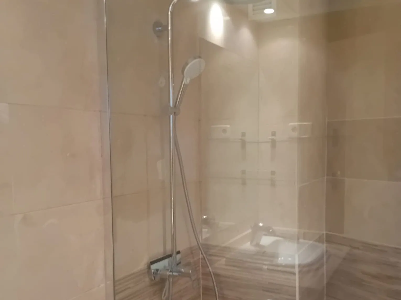Ducha con columna y mampara en un baño reformado por MS Reformas