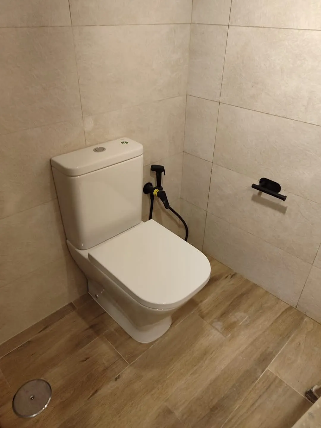Inodoro con grifo de higiene y suelo porcelánico imitación madera